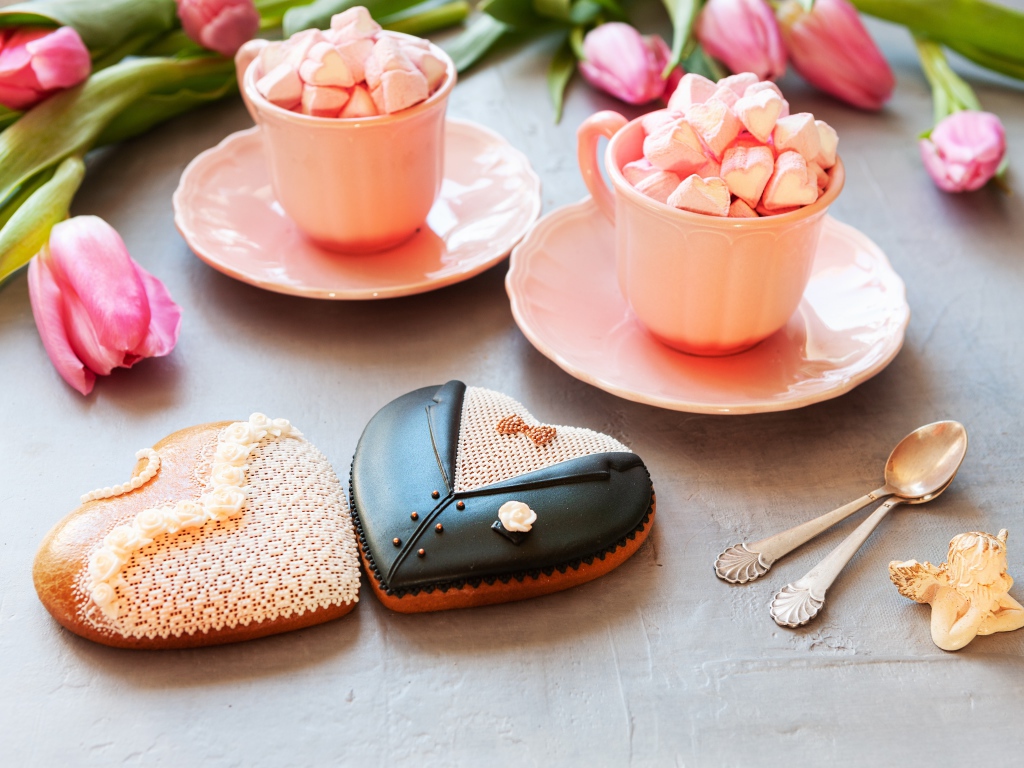 Две розовые чашки с маршмеллоу на сером фоне с печеньем и тюльпанами