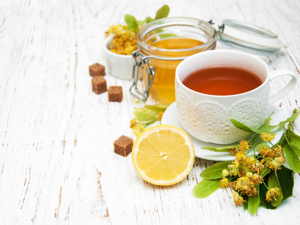 Липовый чай на столе с медом, лимоном, и сахаром