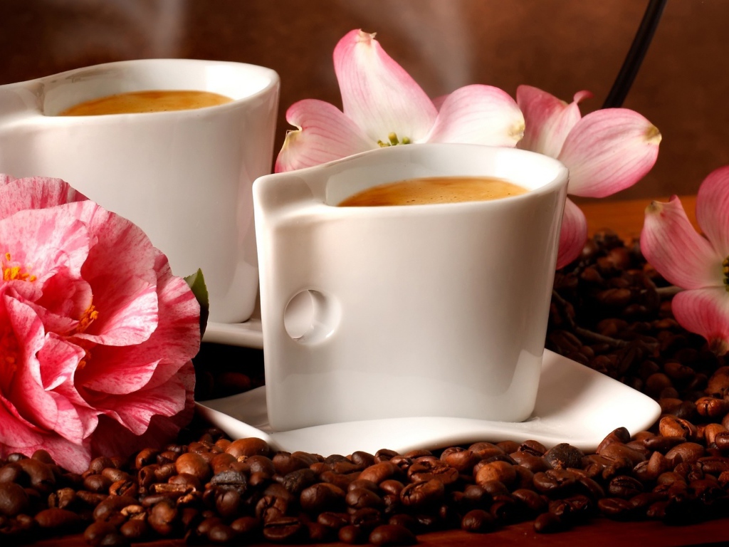 Две чашки кофе на столе с кофейными зернами и цветами