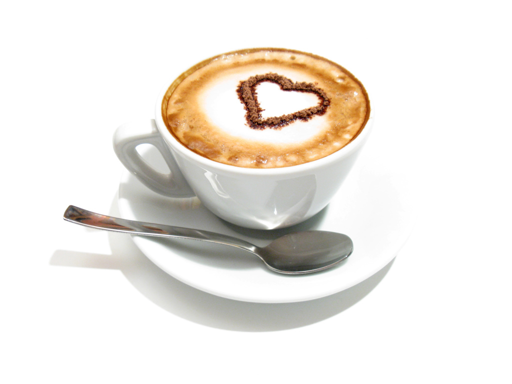 Белая чашка с капучино с сердцем из корицы на пене 