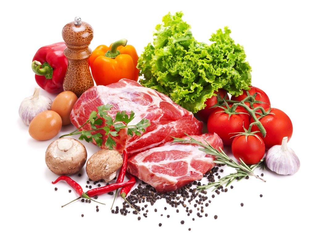 Кусок мяса на белом фоне с овощами и специями