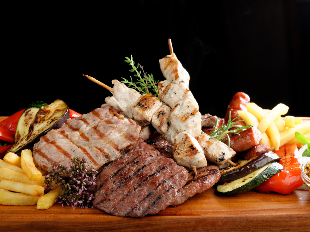 Мясные продукты на столе с картофелем фри 