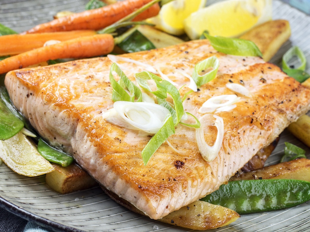 Запеченная красная рыба с овощами на тарелке