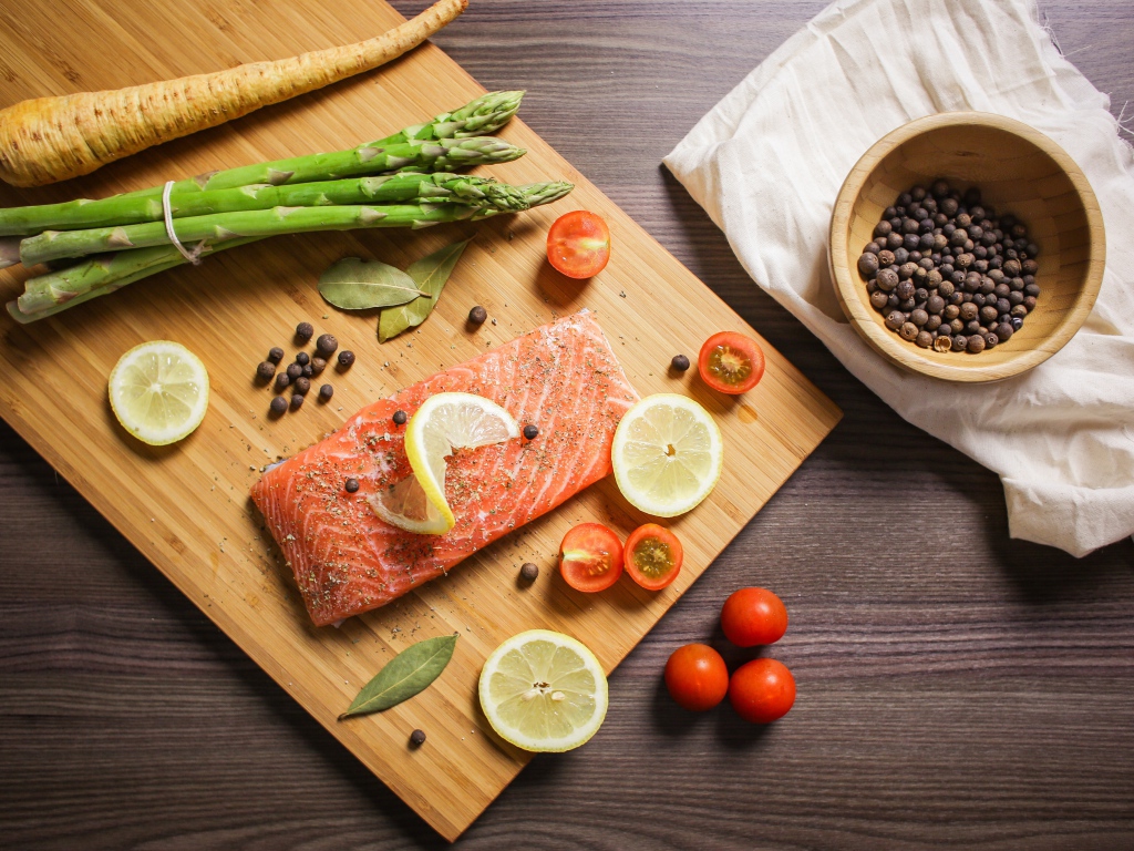 Красная рыба на столе со специями и овощами