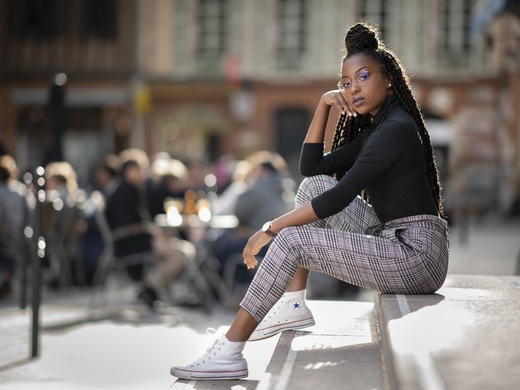 Красивая темнокожая девушка сидит на ступеньках