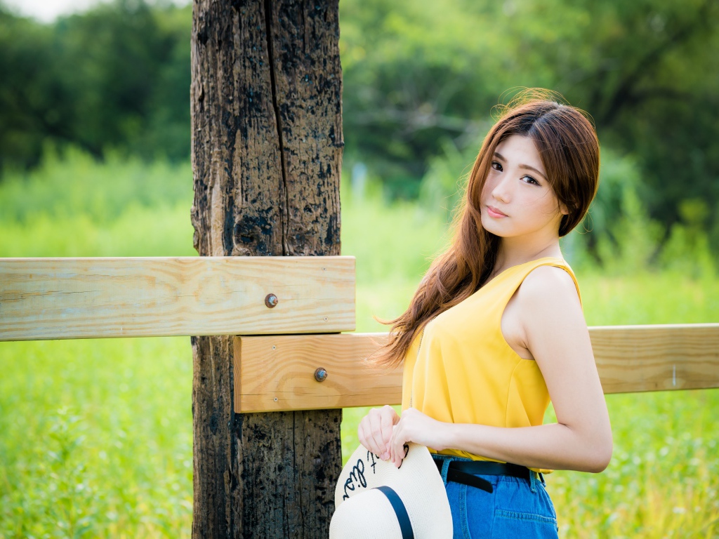 Красивая азиатка у деревянного столба 