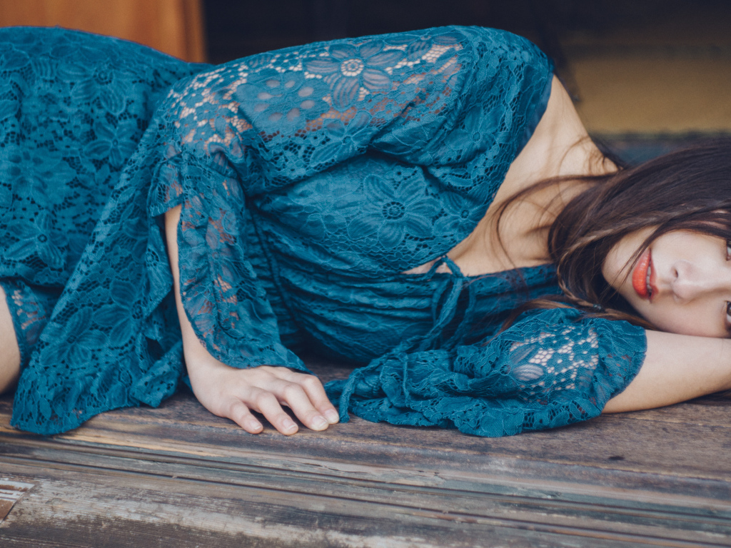 Красивая девушка азиатка в платье лежит на полу