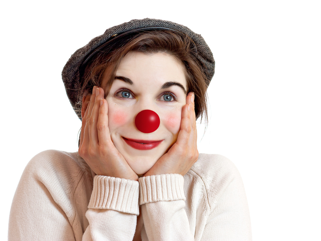 Красивая голубоглазая девушка в кепке с носом клоуна на белом фоне