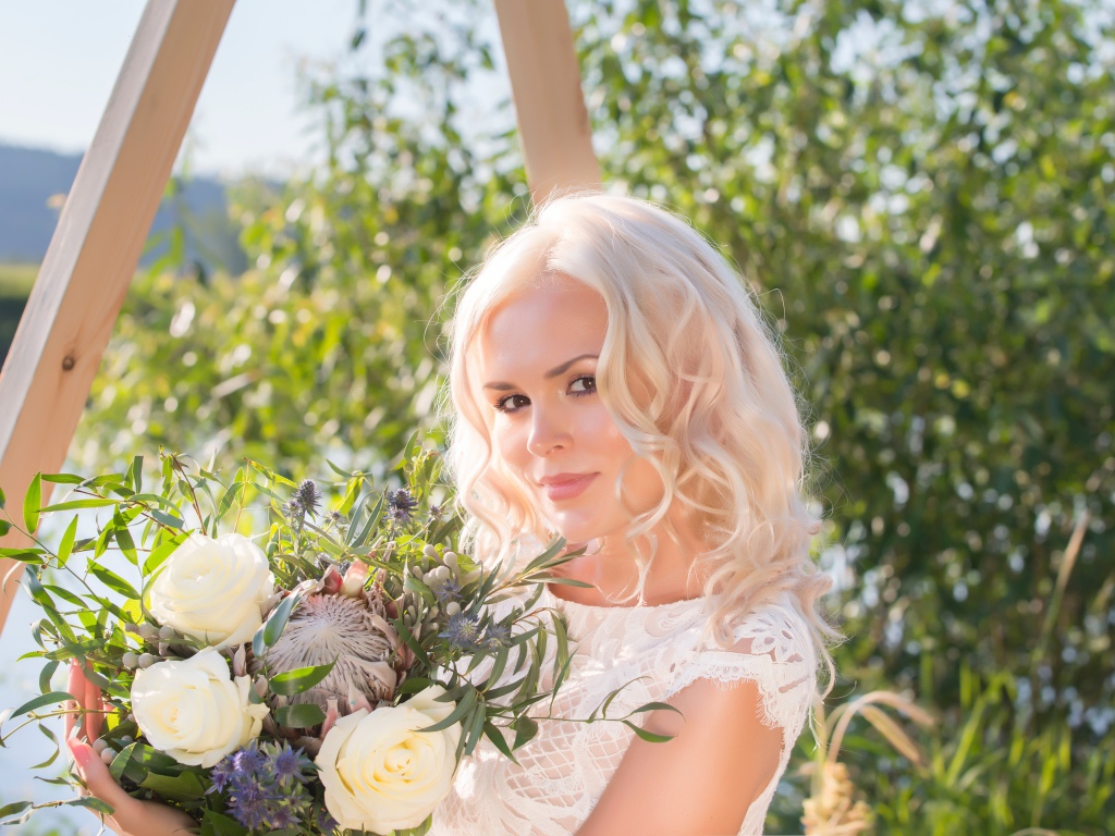 Красивая кареглазая блондинка с букетом в руках 