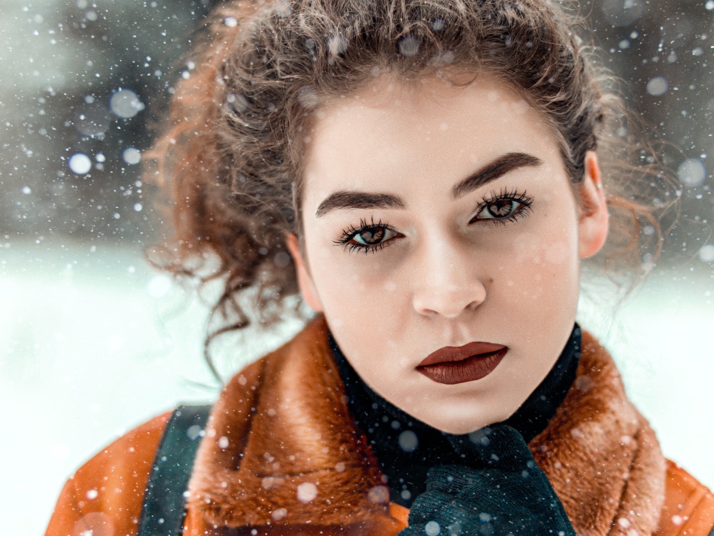 Красивая кареглазая девушка стоит на улице зимой
