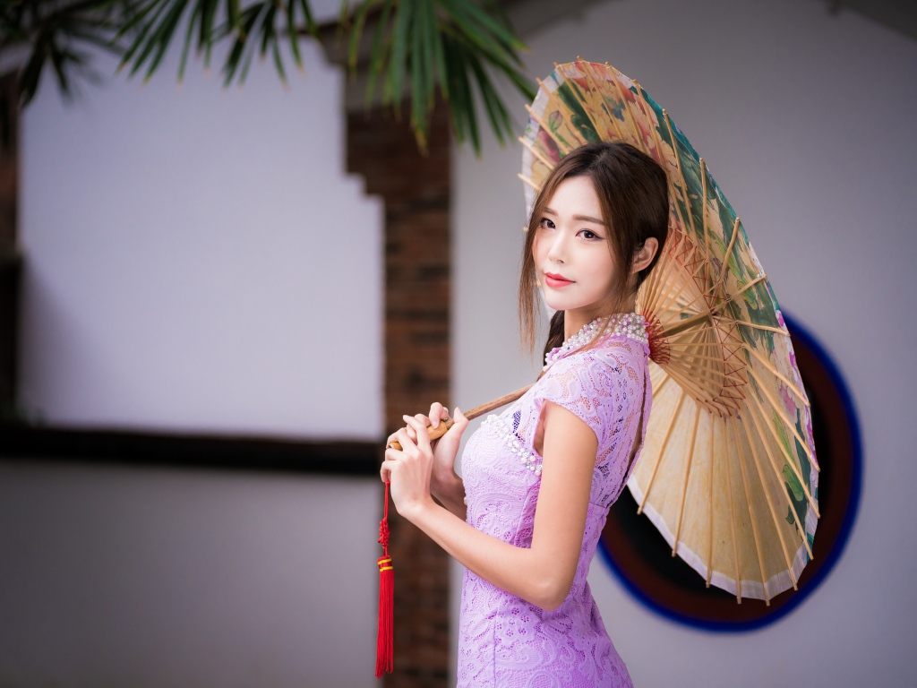 Красивая нежная азиатка в сиреневом платье с зонтом в руках