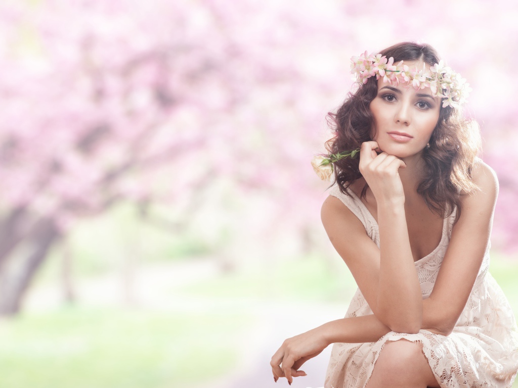 Красивая девушка в розовом платье с венком на голове