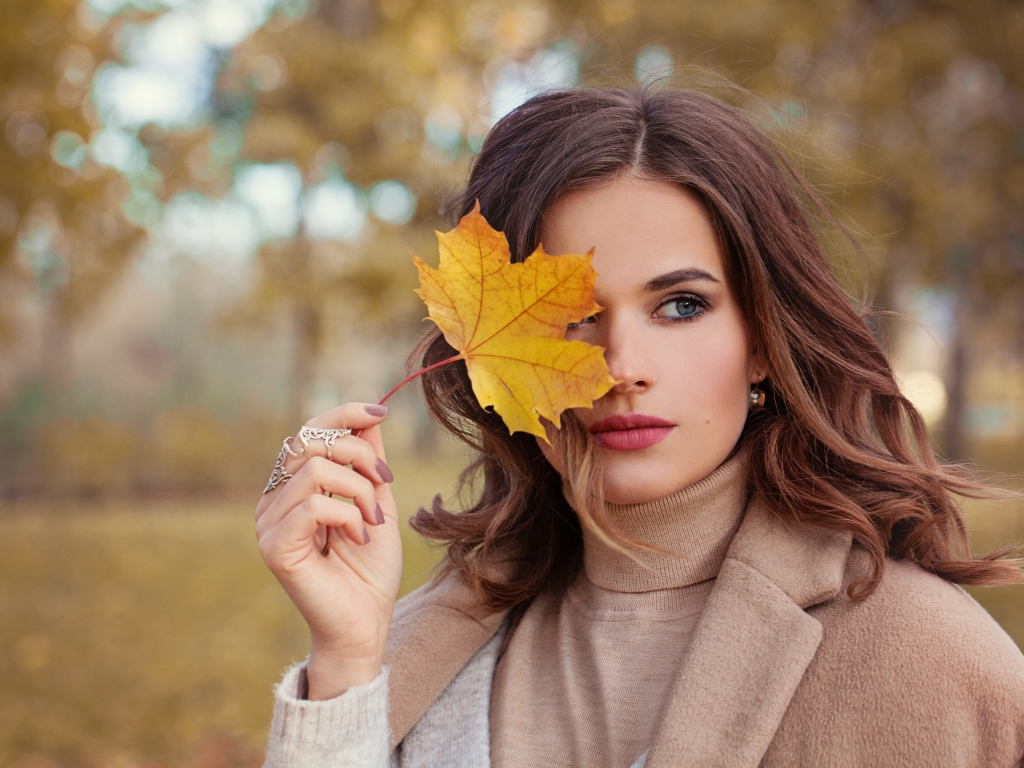 Красивая девушка с осенним листом в руке