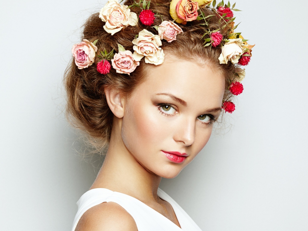 Красивая девушка с цветами в волосах на сером фоне