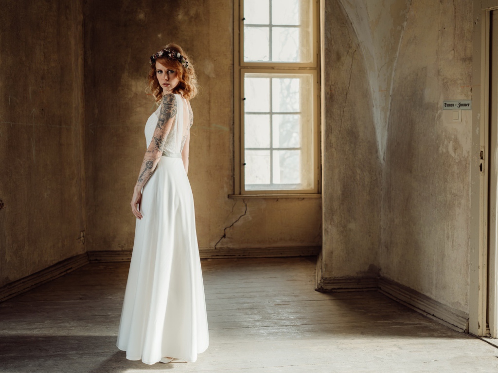 Красивая рыжеволосая девушка в белом платье с  татуировками на теле 