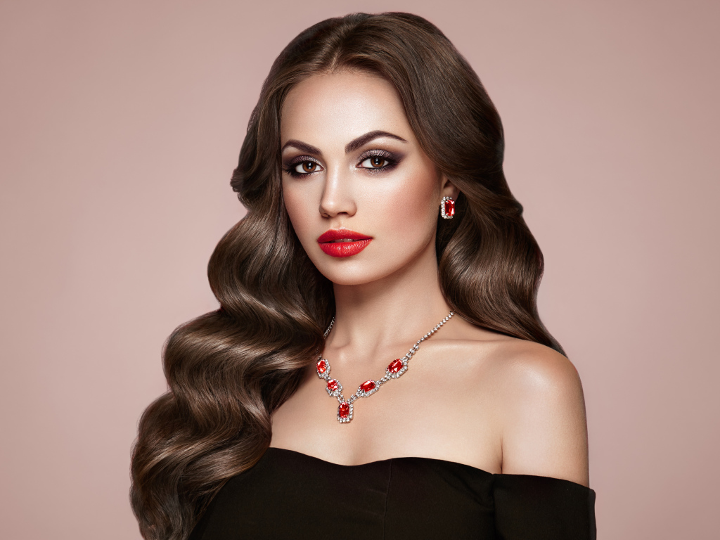 Яркая красивая девушка с украшениями на розовом фоне