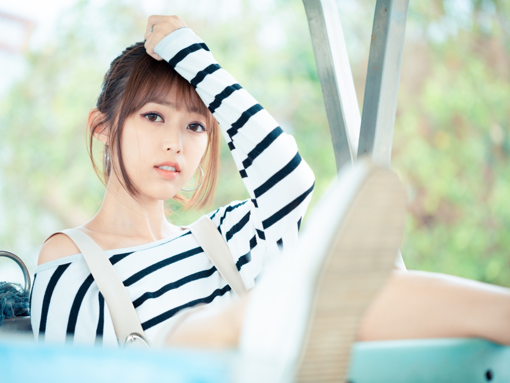 Кареглазая девушка азиатка в полосатом свитере