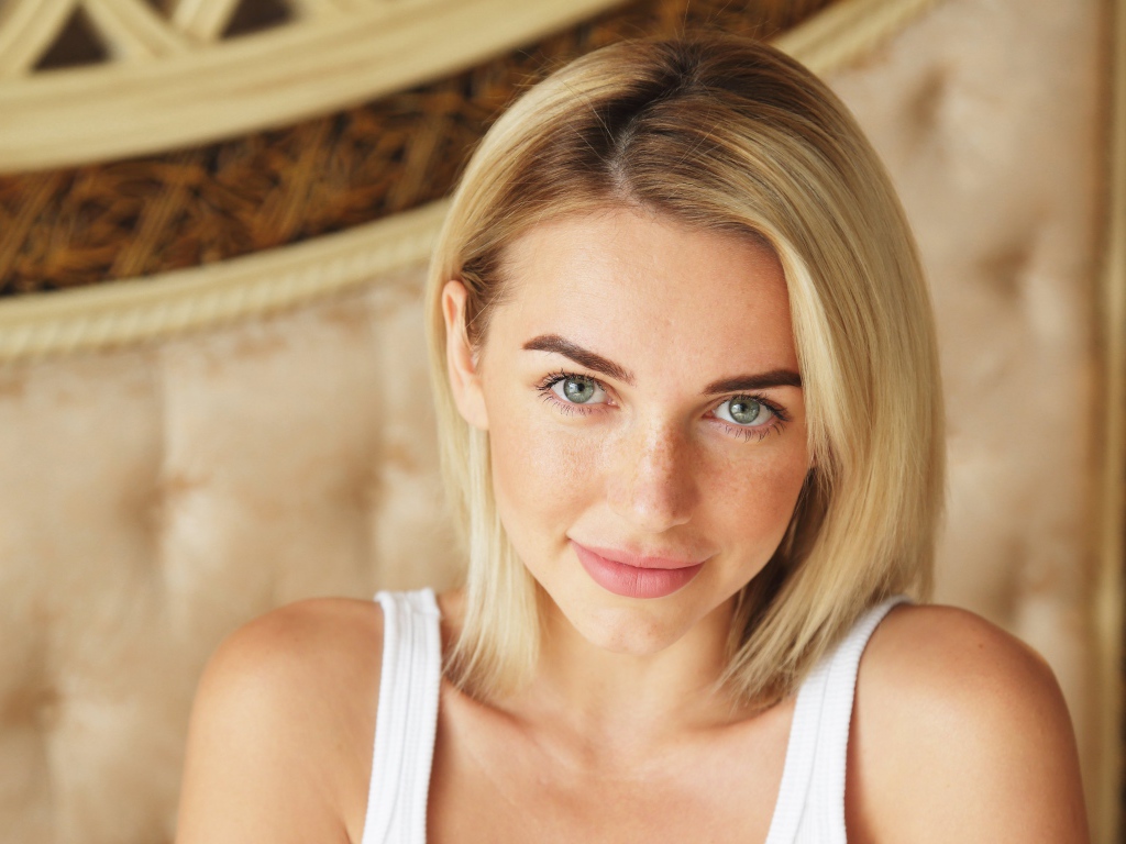 Нежная блондинка с зелеными глазами в белой майке