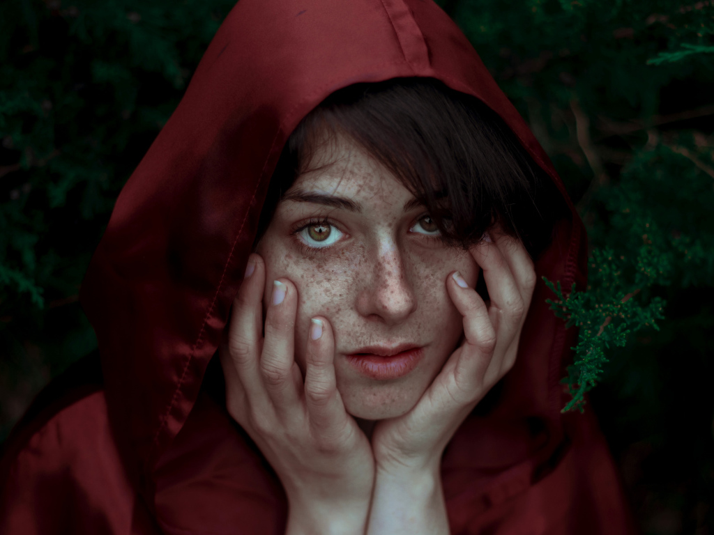 Девушка в красном плаще с веснушками на лице