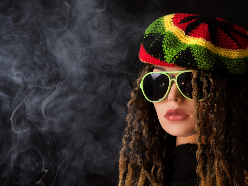 Девушка растаманка в черных очках в дыму