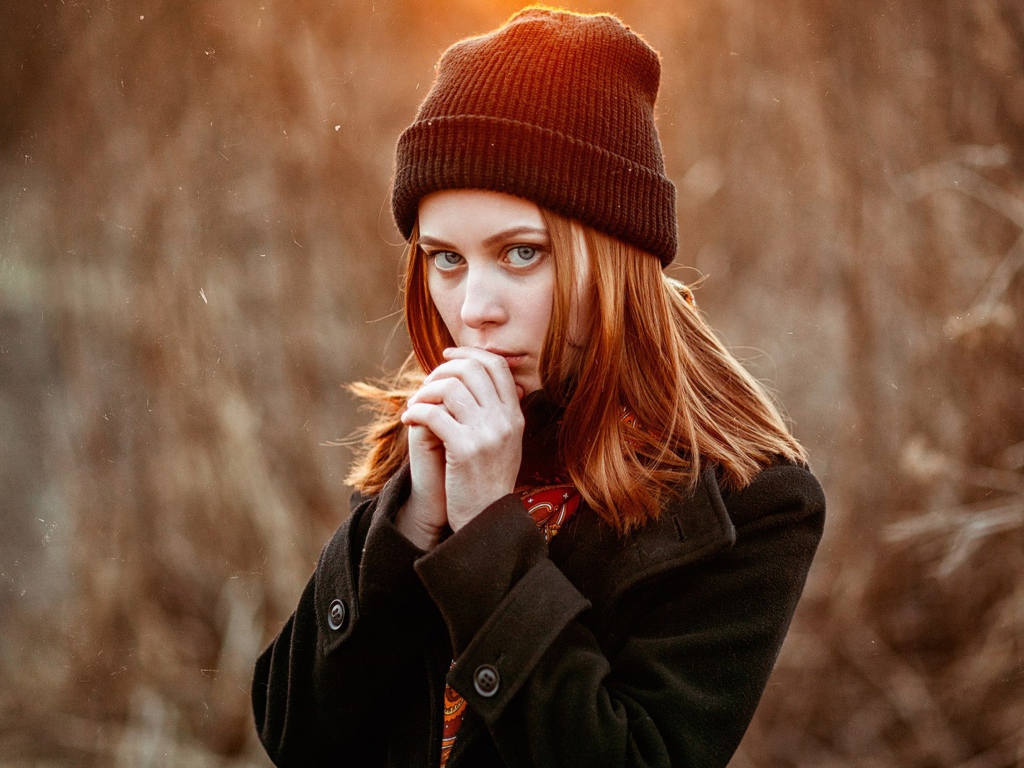 Рыжеволосая девушка в черной шапке в пальто 