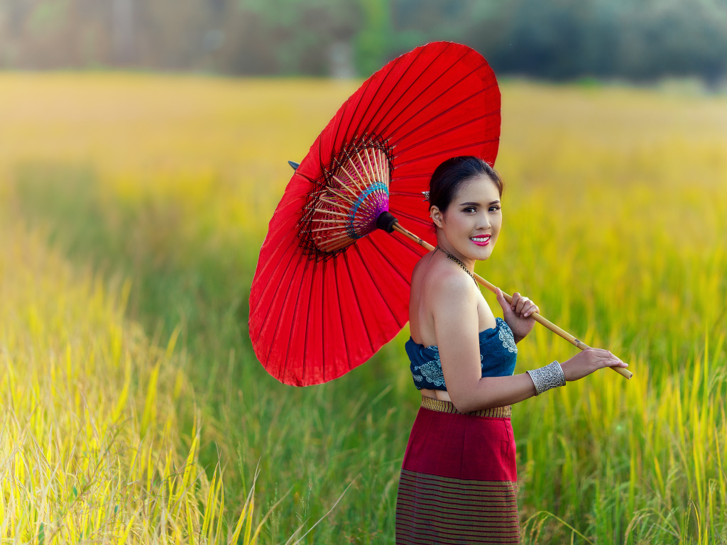 Улыбающаяся девушка азиатка с красным зонтом