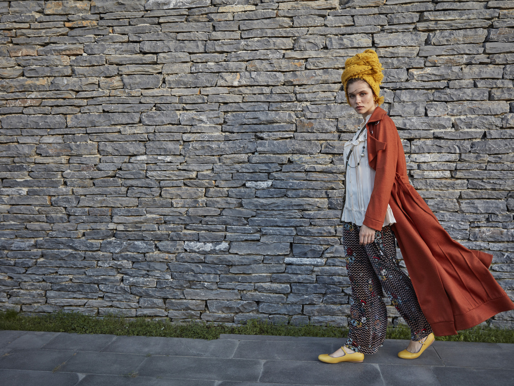 Стильная девушка на фоне стены 