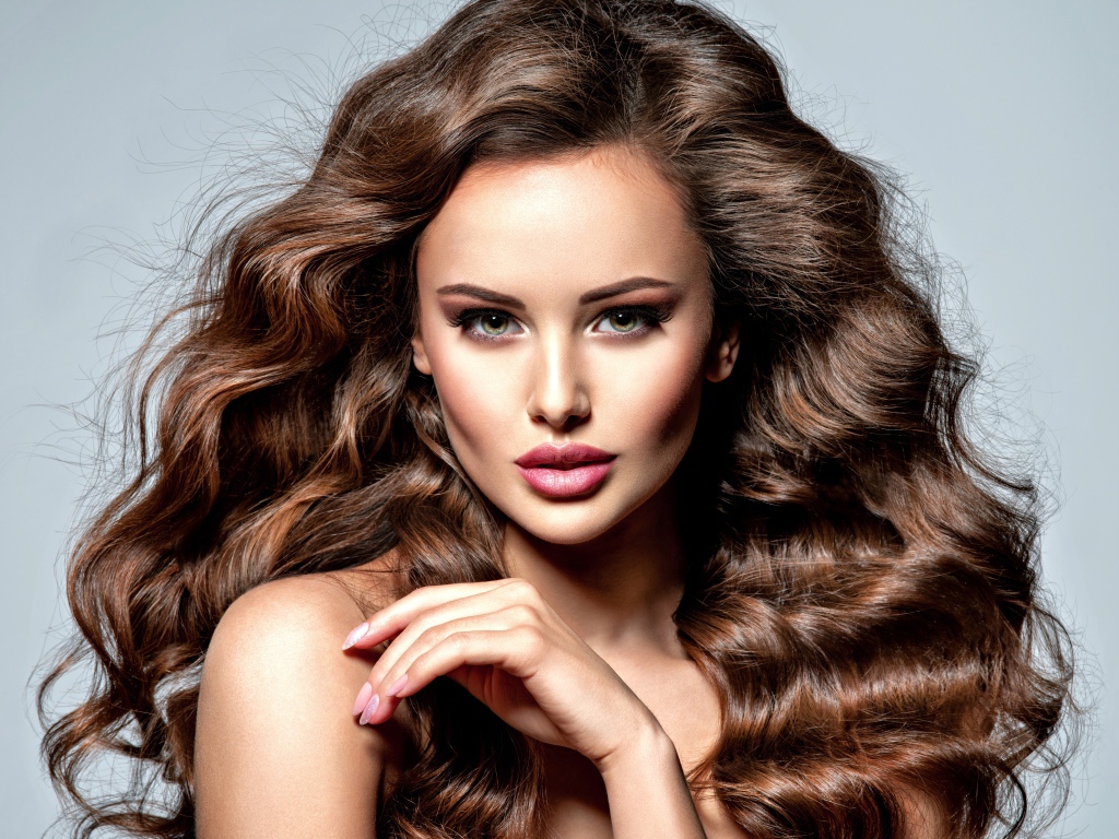 Девушка с красивыми длинными волосами на сером фоне