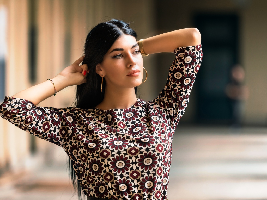 Молодая длинноволосая шатенка с руками в волосах