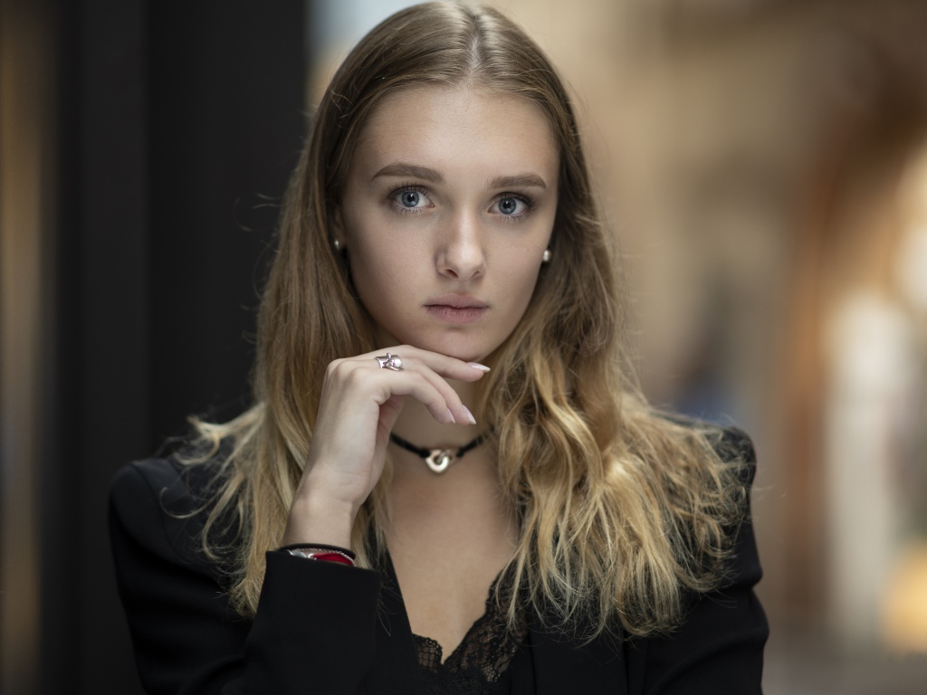 Молодая нежная голубоглазая девушка с рукой у лица