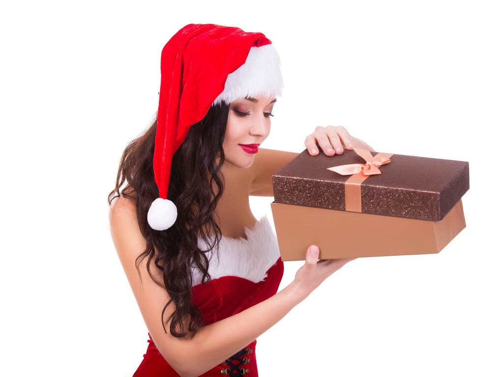 Красивая девушка Снегурочка открывает подарок на белом фоне