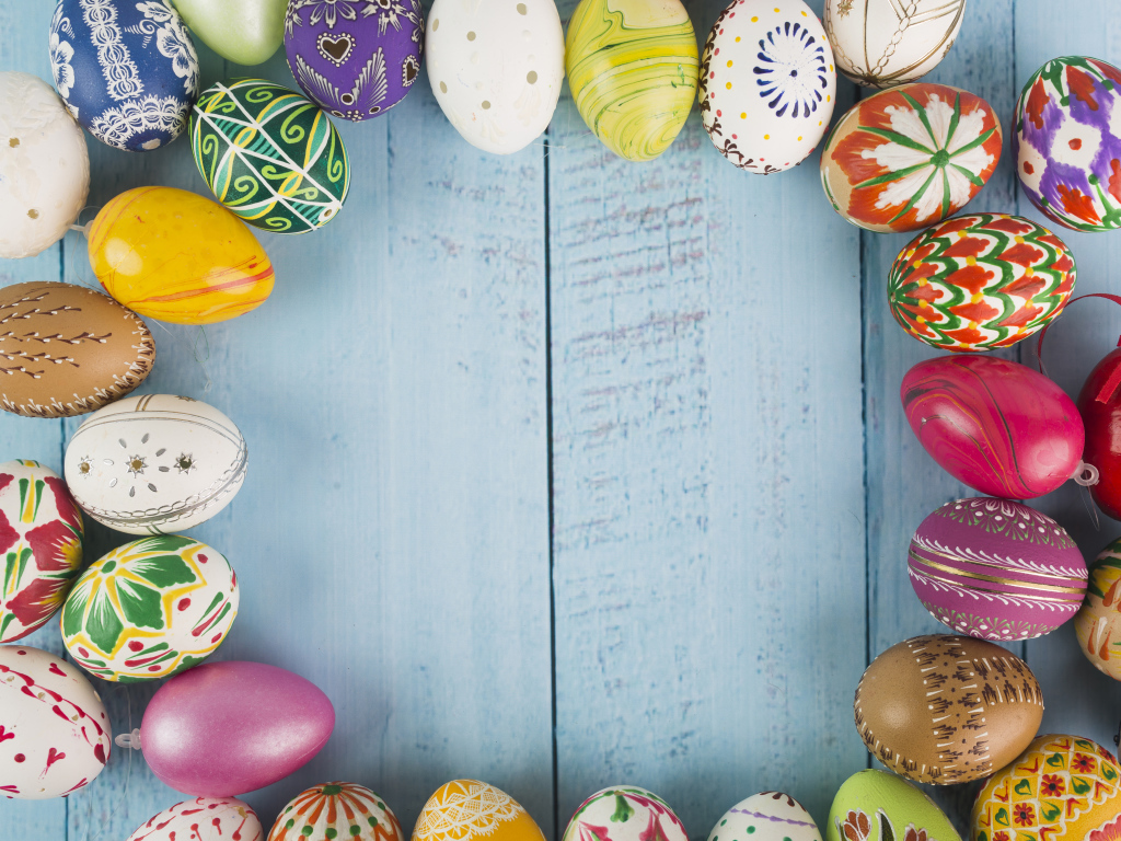 Много крашеных яиц на голубом фоне, шаблон для открытки на Пасху