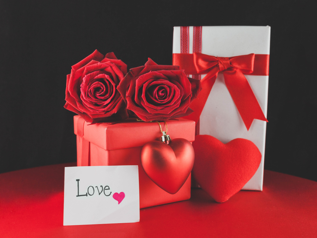 Коробки с подарками на столе с красными розами и сердцем