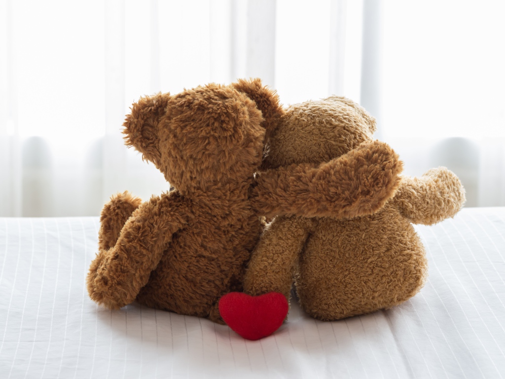 Два влюбленных плюшевых медвежонка на кровати