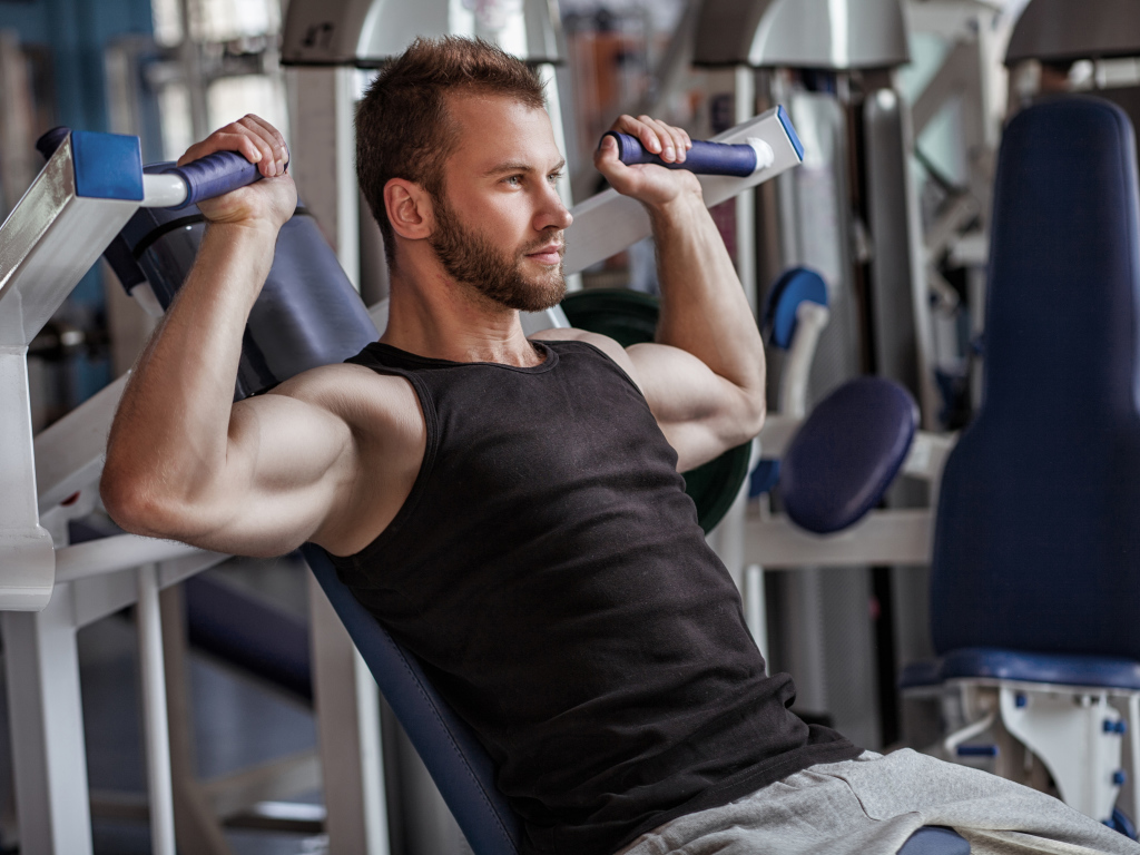 Накаченный мужчина занимается в спортзале