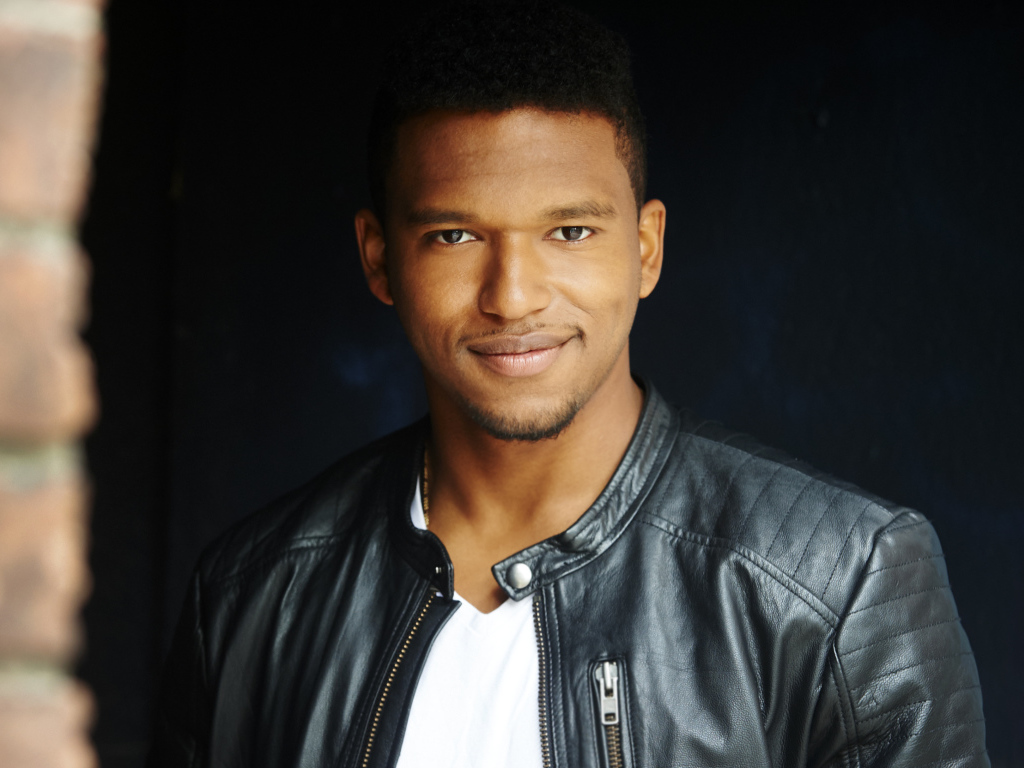 Красивый мужчина в черной куртке, актер Ловелл Адамс-Грей