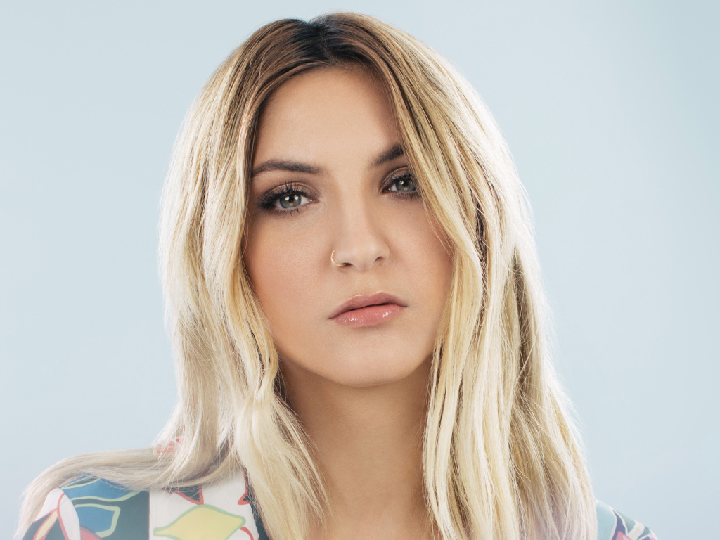 Красивая блондинка, певица Джулия Майклз на сером фоне