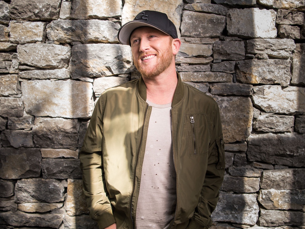 Музыкант Коул Суинделл в бейсболке у стены