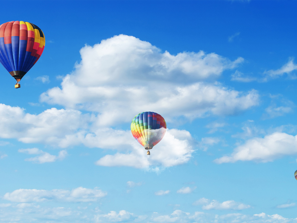 Воздушные шары в голубом небе с белыми облаками 