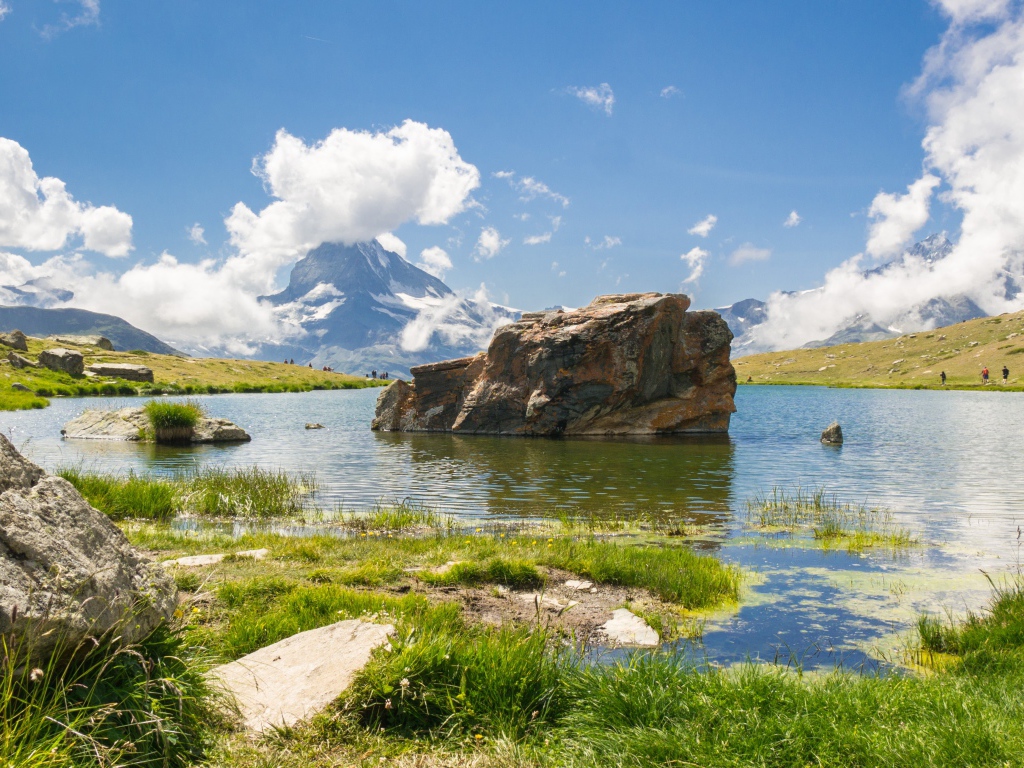 Большой камень в воде на фоне голубого неба
