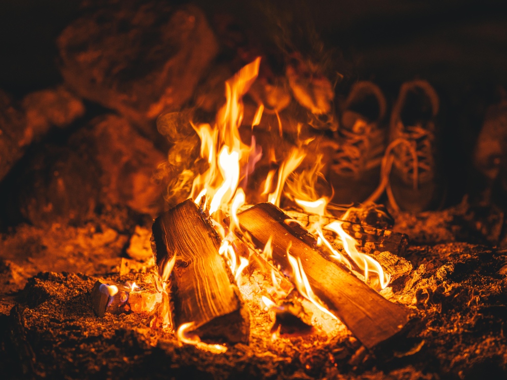 Дрова лежат в ярком огне костра