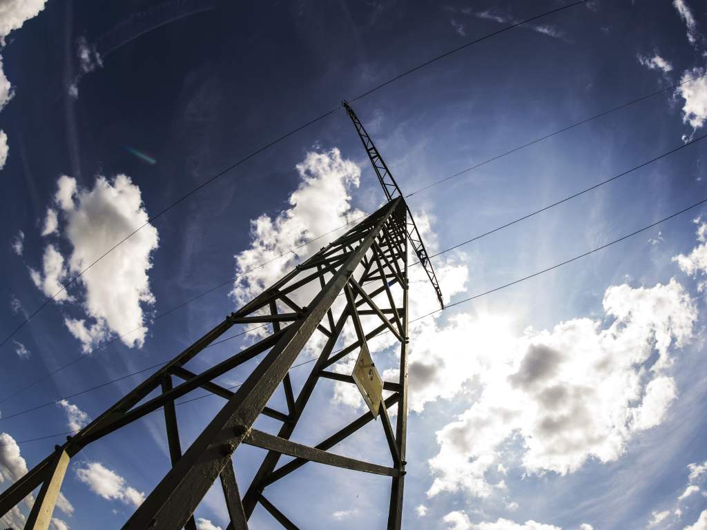 Столб линии электропередач на фоне голубого неба с облаками