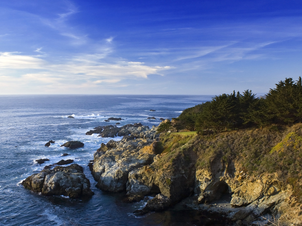 Каменные скалы береговой линии в океане под голубым небом