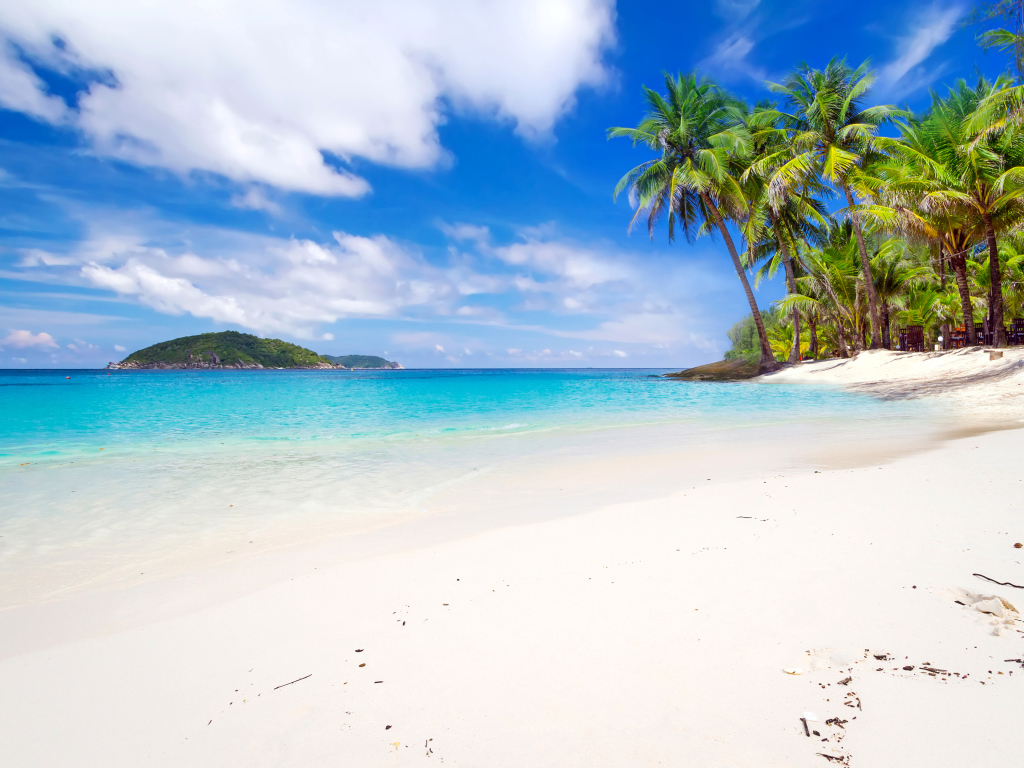 Белый песок на тропическом пляже с голубой водой 