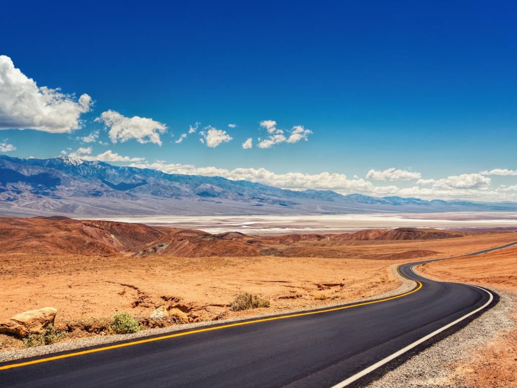 Дорога в пустыне под красивым голубым небом с белыми облаками
