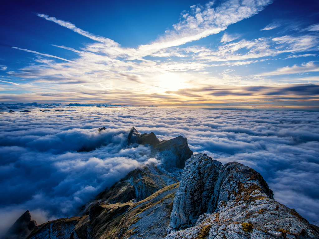 Густые белые облака над вершинами гор на рассвете