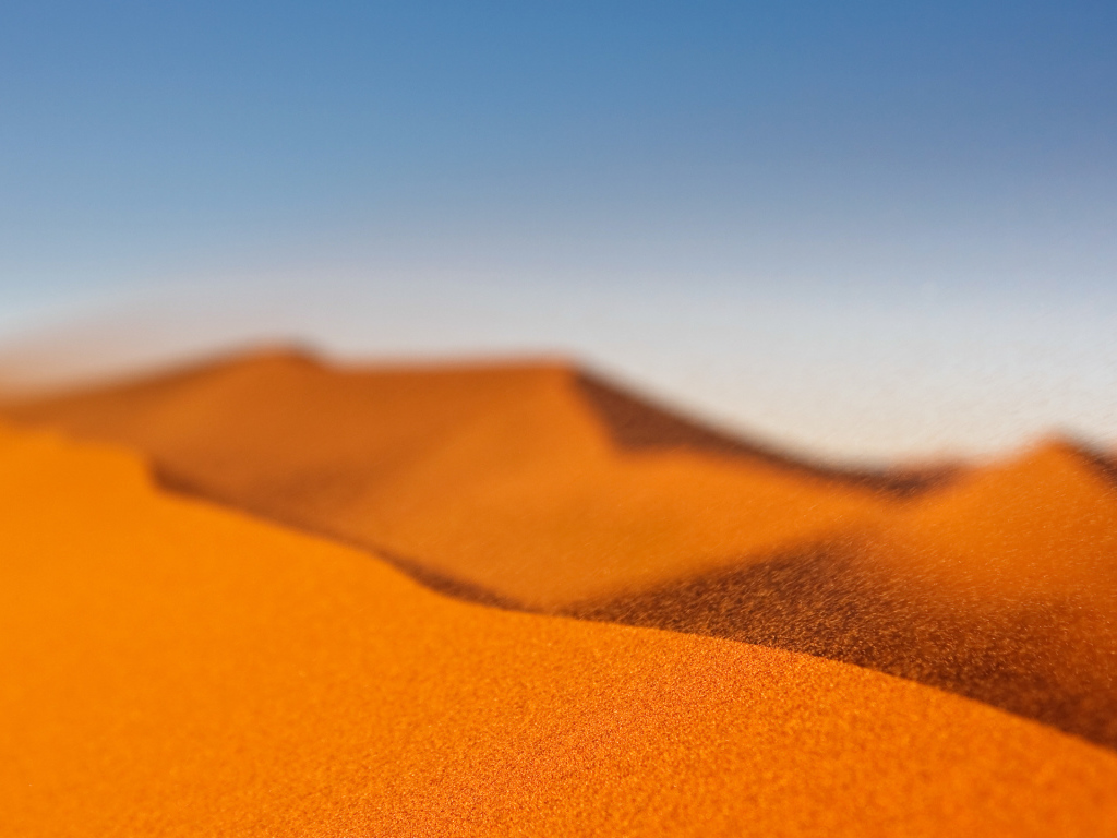 Желтый песок в пустыне под голубым небом