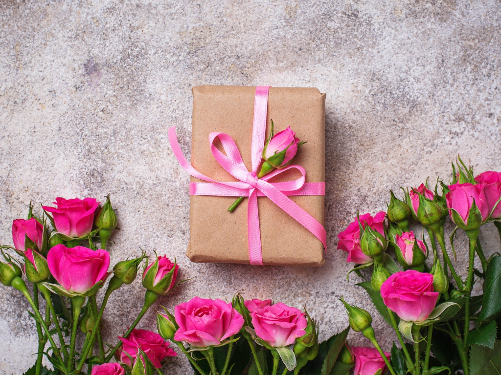 Подарок на сером фоне с букетом розовых роз