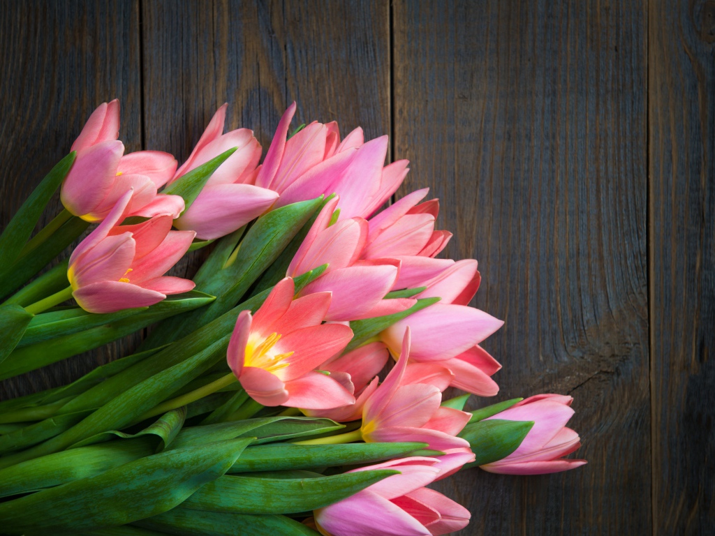 Красивый букет розовых тюльпанов на деревянном столе