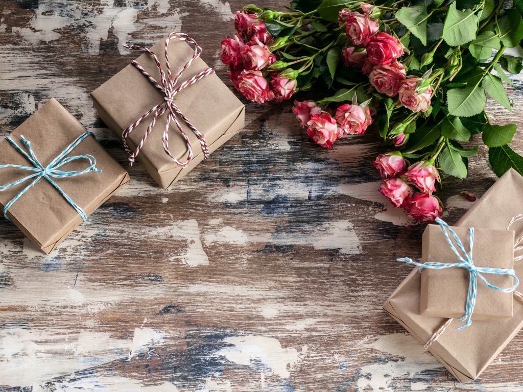 Подарочные коробки на деревянной поверхности с букетом роз